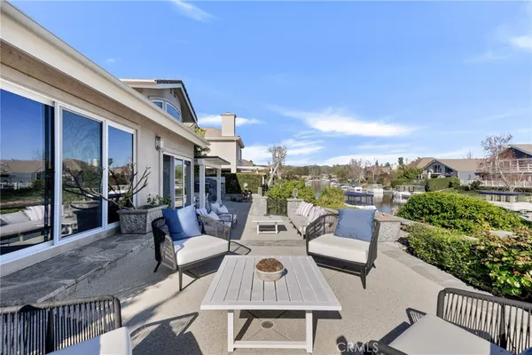 a view of a patio with couches chairs potted plants and city view