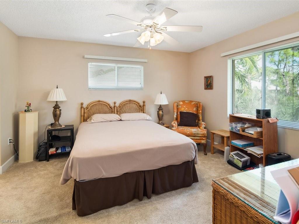 3012 Sandpiper Bay Circle, Unit D301 Naples, FL 34112 - Photo 11 of 23 a bedroom with a bed and wooden floor