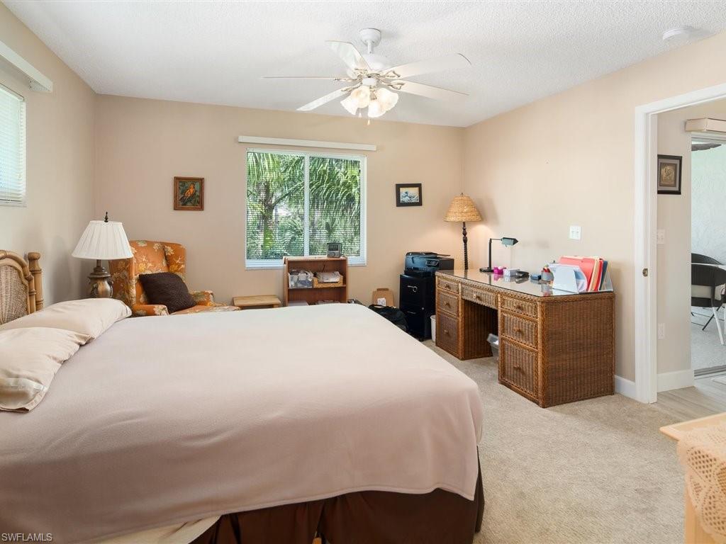 3012 Sandpiper Bay Circle, Unit D301 Naples, FL 34112 - Photo 12 of 23 a bed room with a bed and a chandelier