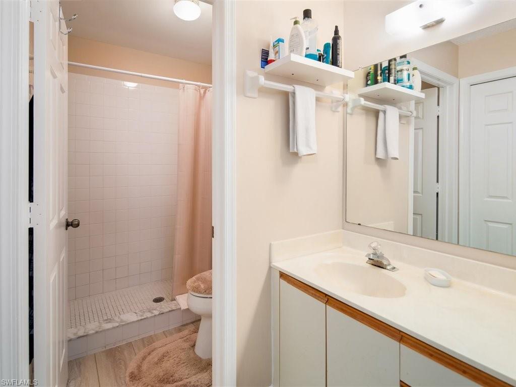 3012 Sandpiper Bay Circle, Unit D301 Naples, FL 34112 - Photo 13 of 23 a bathroom with a sink vanity and a mirror