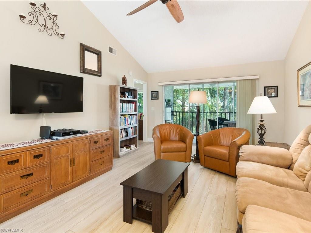 3012 Sandpiper Bay Circle, Unit D301 Naples, FL 34112 - Photo 2 of 23 a living room with furniture and a flat screen tv