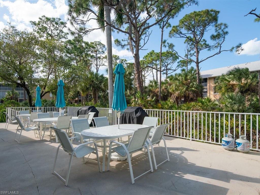 3012 Sandpiper Bay Circle, Unit D301 Naples, FL 34112 - Photo 22 of 23 a view of a patio with a table and chairs