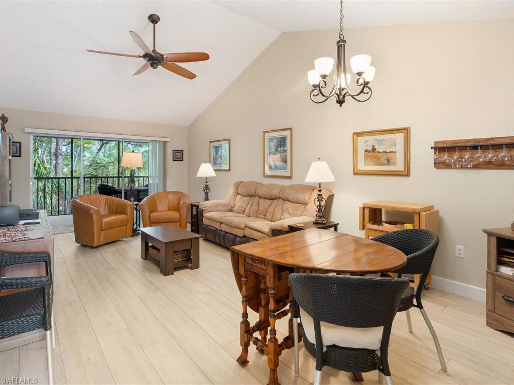 3012 Sandpiper Bay Circle, Unit D301 Naples, FL 34112 - Photo 3 of 23 a view of a dining room with furniture a chandelier and wooden floor