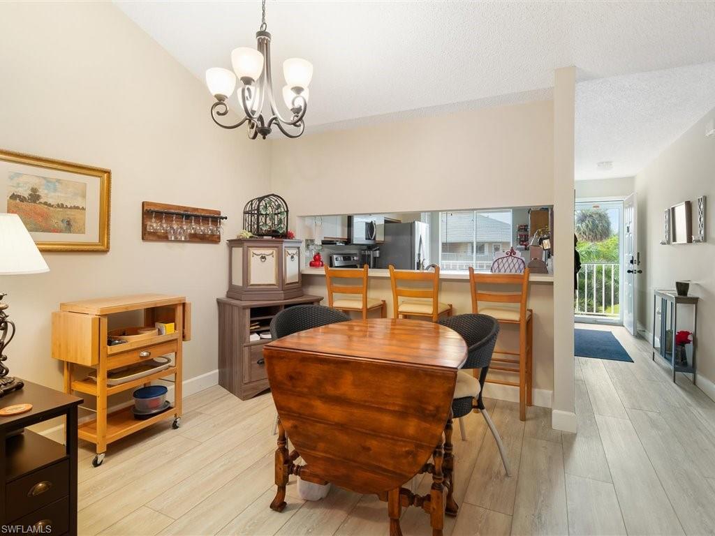 3012 Sandpiper Bay Circle, Unit D301 Naples, FL 34112 - Photo 4 of 23 a dining room with furniture and a chandelier