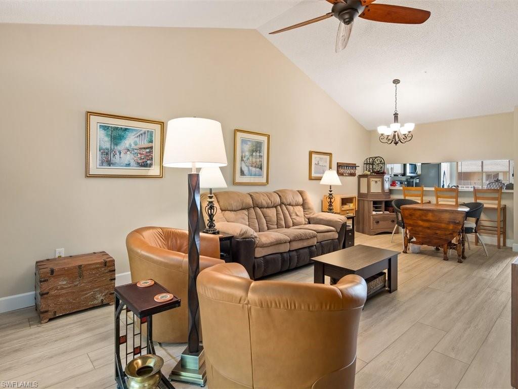 3012 Sandpiper Bay Circle, Unit D301 Naples, FL 34112 - Photo 5 of 23 a living room with furniture and a chandelier
