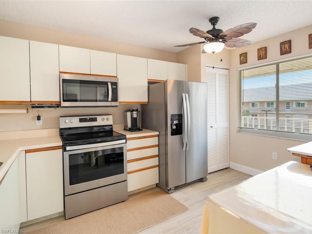 3012 Sandpiper Bay Circle, Unit D301 Naples, FL 34112 - Photo 7 of 23 a kitchen with stainless steel appliances a stove a refrigerator cabinets and a sink