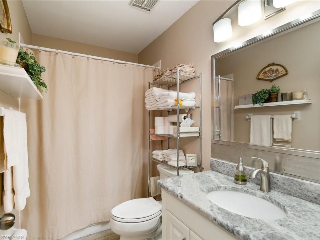 3012 Sandpiper Bay Circle, Unit D301 Naples, FL 34112 - Photo 10 of 23 a bathroom with a granite countertop sink toilet and shower