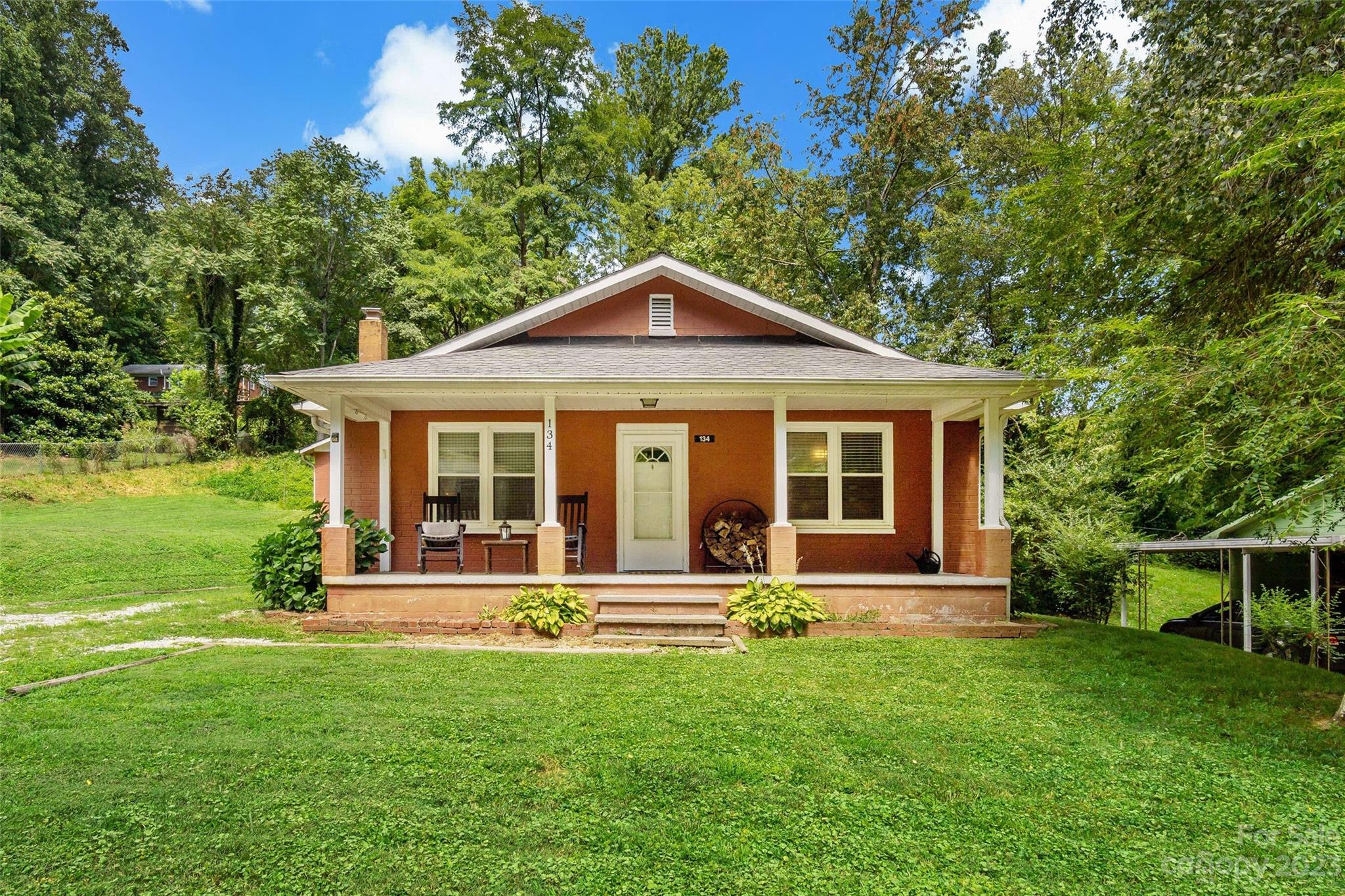 134 Spring Street Old Fort, NC 28762 - Photo 1 of 34 a front view of a house with a yard table and chairs