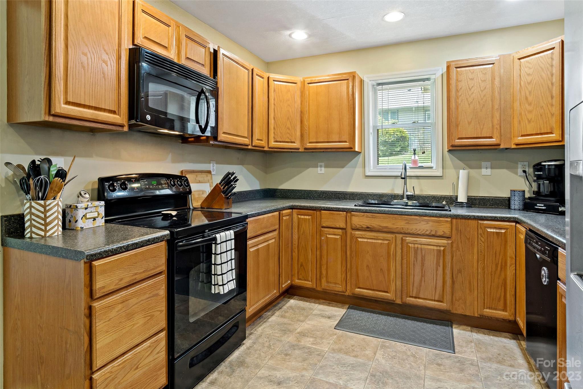 134 Spring Street Old Fort, NC 28762 - Photo 18 of 34 a kitchen with stainless steel appliances granite countertop a stove a sink dishwasher and a microwave