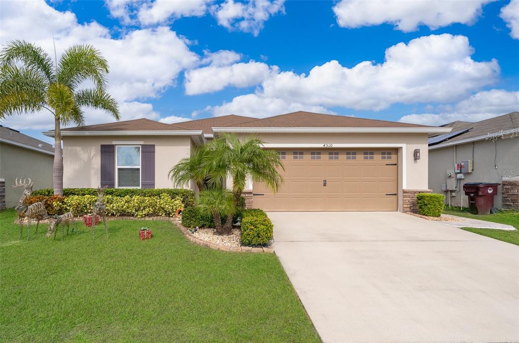 a front view of a house with a yard and garage