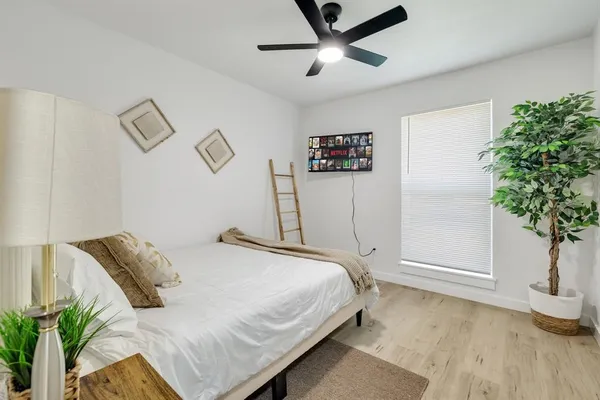 a bedroom with a bed and a potted plant