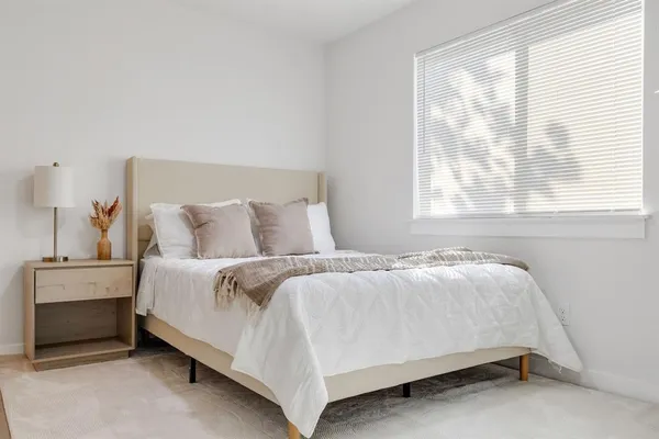 a bed sitting in a bedroom next to a window