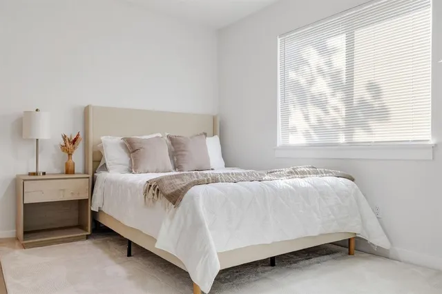 a bed sitting in a bedroom next to a window
