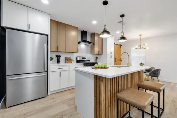 a kitchen with kitchen island a refrigerator a stove a sink and a refrigerator