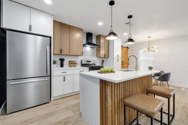 a kitchen with kitchen island a refrigerator a stove a sink and a refrigerator