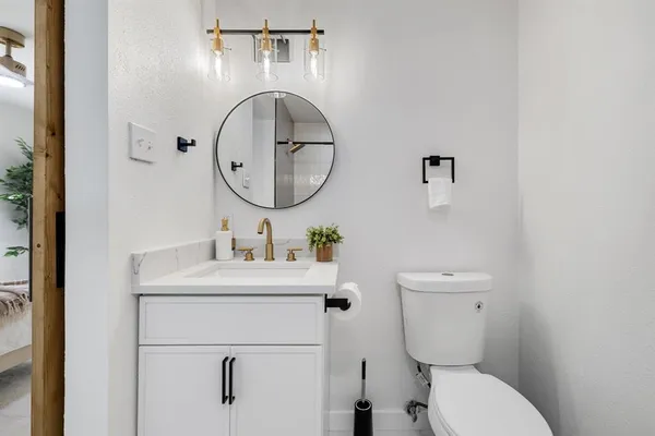 a bathroom with a toilet sink and mirror