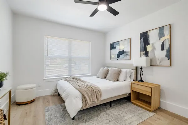 a bedroom with a bed and a painting on the wall