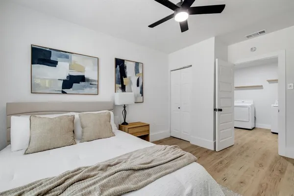 a bedroom with a bed and a painting on the wall