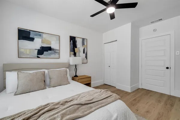 a bedroom with a bed and a painting on the wall