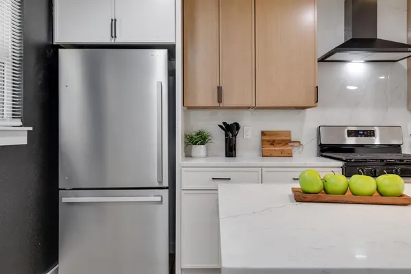 a kitchen with stainless steel appliances a refrigerator and a counter top space