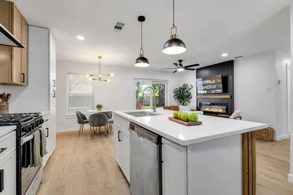 a kitchen with a sink a stove and chairs
