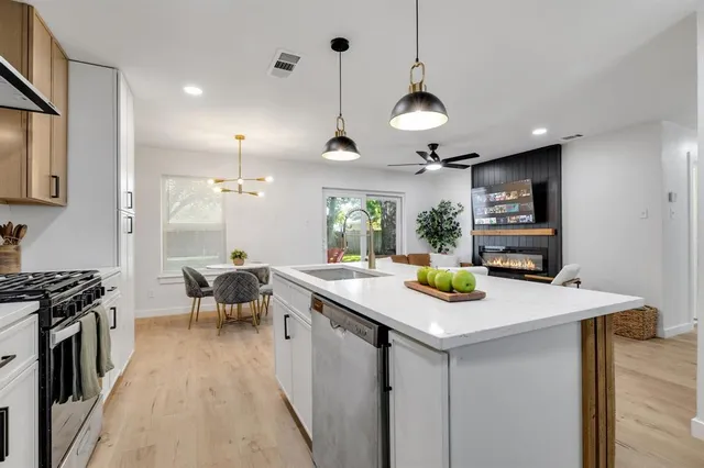 a kitchen with a sink a stove and chairs