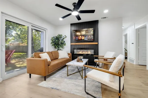 a living room with furniture a large window and a flat screen tv