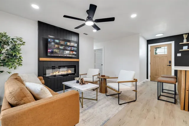 a living room with furniture a flat screen tv and a fireplace