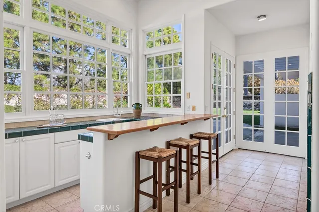 a dining hall with stainless steel appliances granite countertop a table and chairs in it
