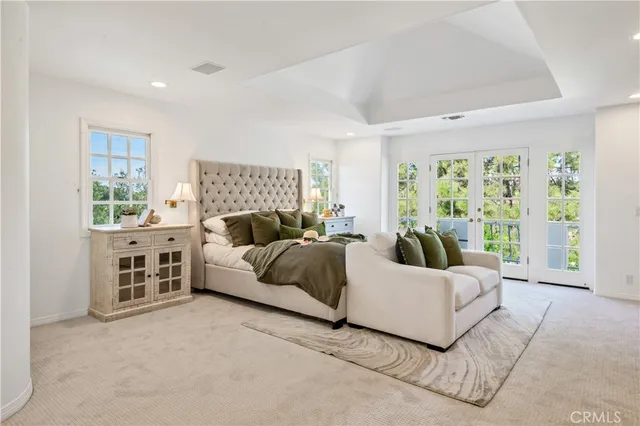 a spacious bedroom with a bed and glass window