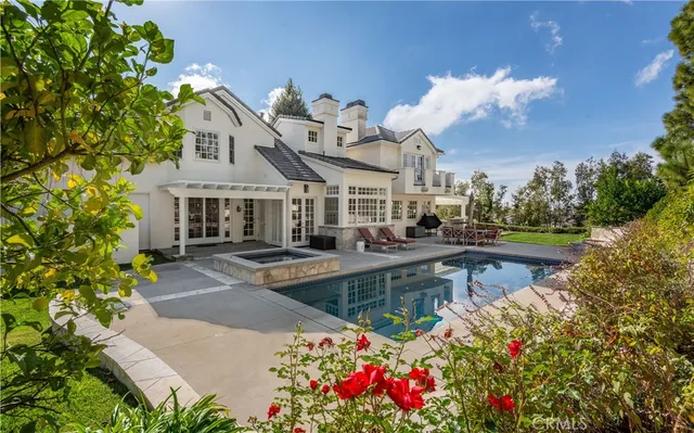 a view of a house with swimming pool and sitting area