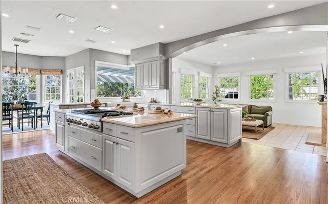 a large kitchen with stainless steel appliances a stove a sink a dining table and chairs
