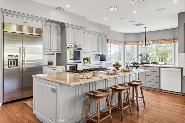 a kitchen with kitchen island granite countertop a sink and cabinets