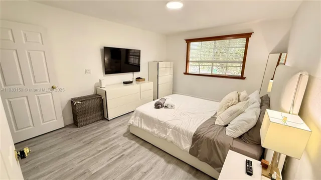 a bedroom with a bed and flat screen tv