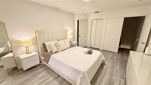 a spacious bedroom with a bed and a large mirror
