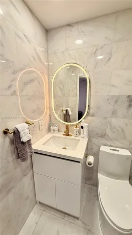 a bathroom with a toilet a sink and a mirror