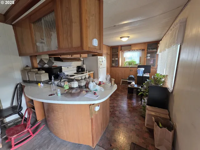 a room with wooden floor pool table and chairs