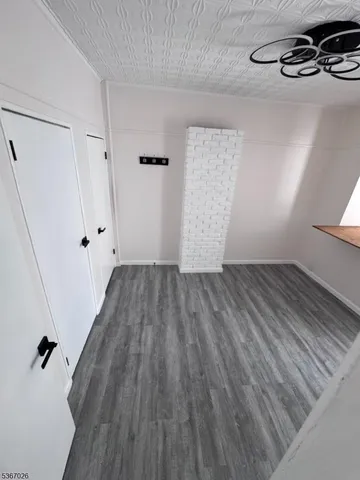 a view of a room with wooden floor and white walls
