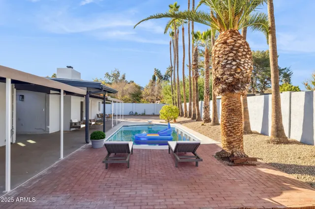 a backyard of a house with barbeque oven table and chairs