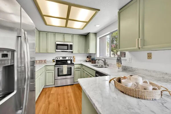 a kitchen with kitchen island granite countertop a stove and a sink