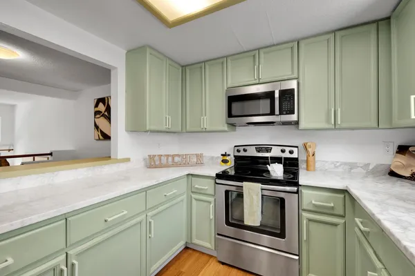a kitchen with granite countertop a stove top oven microwave and cabinets