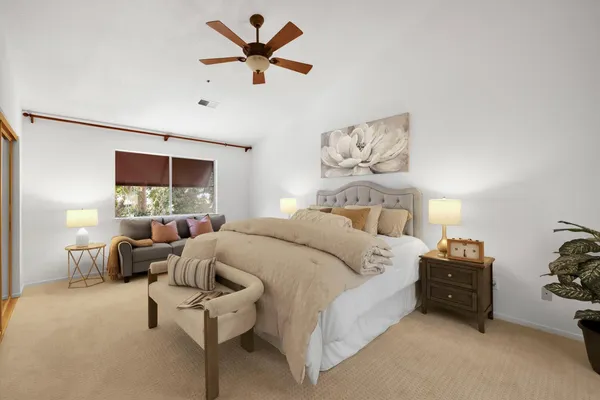 a spacious bedroom with a bed and a chandelier