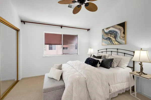 a bedroom with a bed and painting on the wall