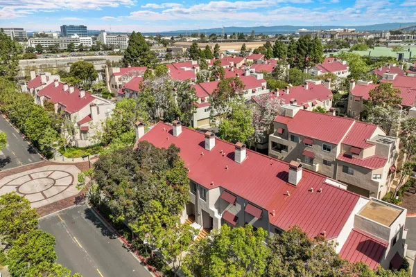 an aerial view of a city with lots of residential buildings and mountain view in back