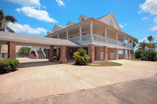 an empty room with wooden floor chandelier and windows