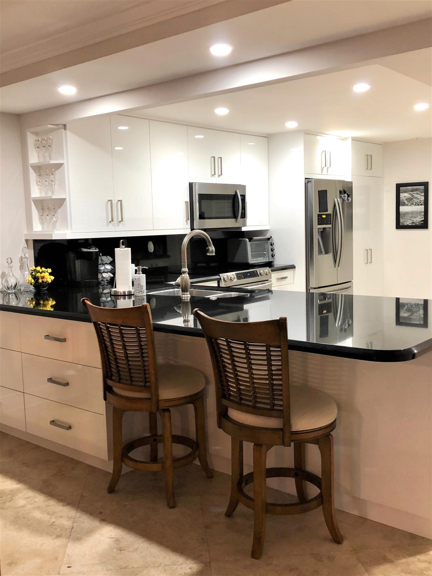 1631 Riverview Road, Unit 102 Deerfield Beach, FL 33441 - Photo 5 of 37 a kitchen with a table chairs microwave and refrigerator