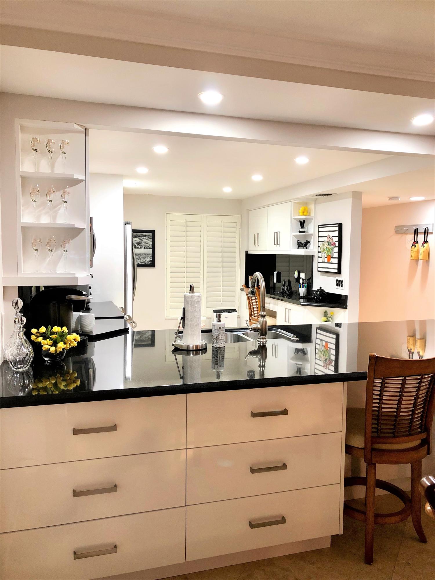 1631 Riverview Road, Unit 102 Deerfield Beach, FL 33441 - Photo 6 of 37 a kitchen with granite countertop white cabinets and stainless steel appliances