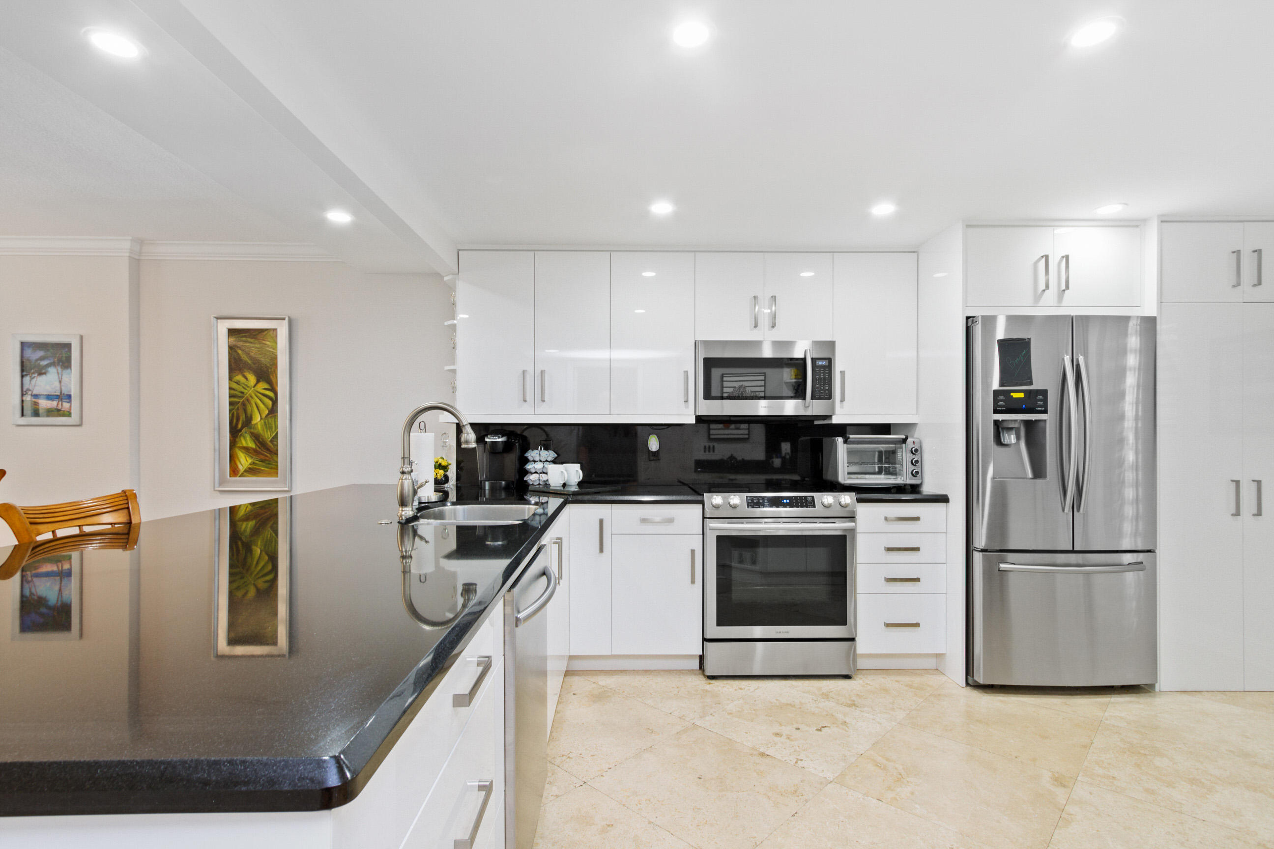 1631 Riverview Road, Unit 102 Deerfield Beach, FL 33441 - Photo 8 of 37 a kitchen with kitchen island a counter top space cabinets stainless steel appliances and a counter space