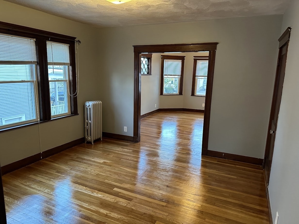 90 Boylston Street, Unit 1 Watertown, MA 02472 - Photo 6 of 16 a view of an empty room with wooden floor and a window