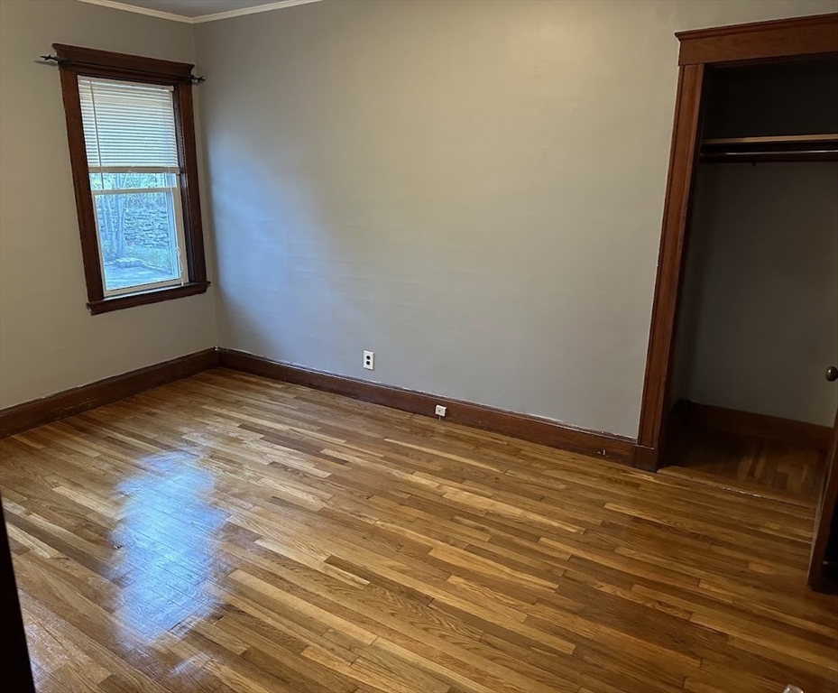 90 Boylston Street, Unit 1 Watertown, MA 02472 - Photo 8 of 16 a view of an empty room with wooden floor and a window